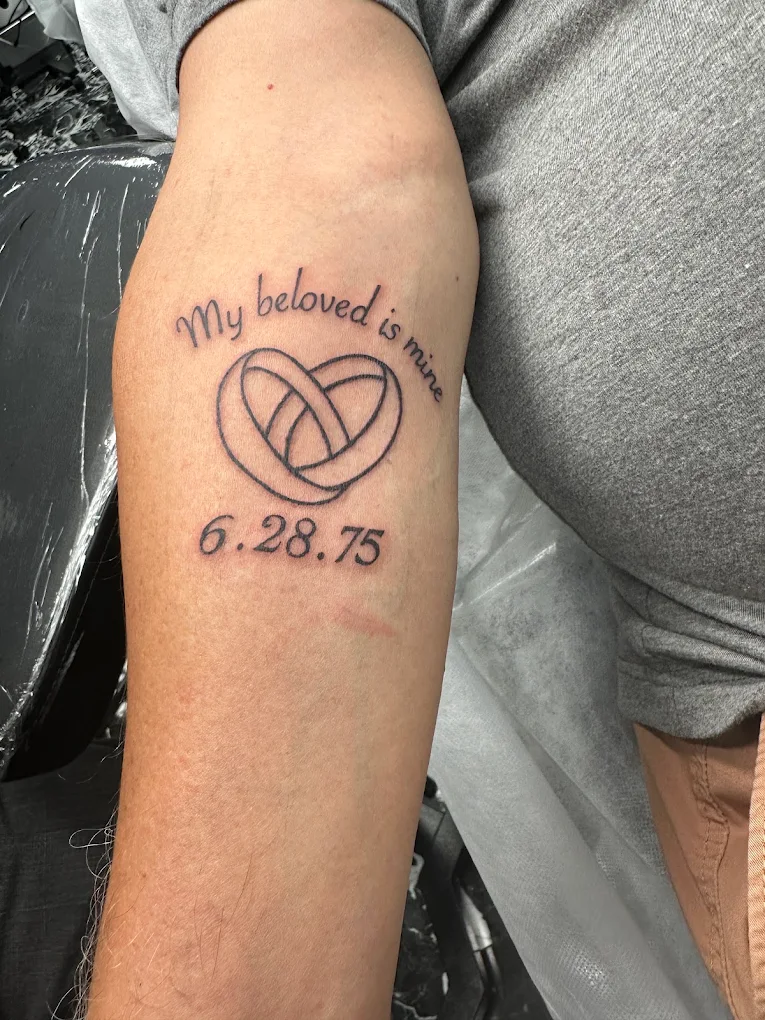 Fine line heart and date tattoo on a wrist from the Secret Ink portfolio